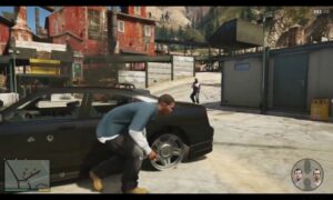 Screenshot from Grand Theft Auto V showing a male character in a blue shirt and white undershirt stealing a black car on a sunlit street with buildings and pedestrians visible in the background.