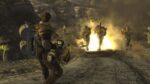 Player character in Fallout: New Vegas facing armored troops running through flames in a rocky desert canyon environment