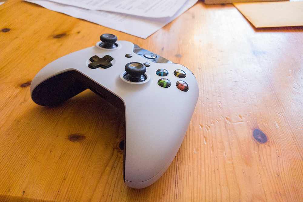 White Xbox One wireless controller on a light surface