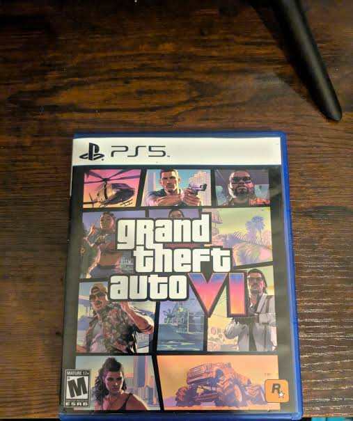 Grand Theft Auto VI physical box art for PlayStation 5, featuring the game's signature neon-soaked key art with palm trees and a vintage car against a pink and purple sunset skyline.